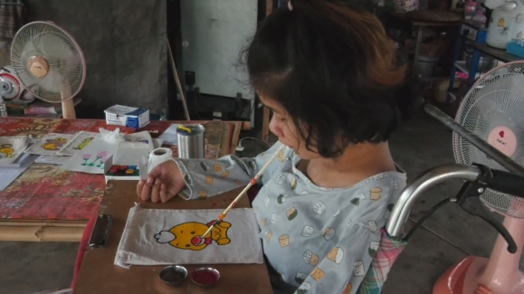 วอนช่วย สาวพิการ สู้ชีวิตใช้ปากคาบพู่กันเพ้นท์กระเป๋าผ้าขายเลี้ยงชีพ